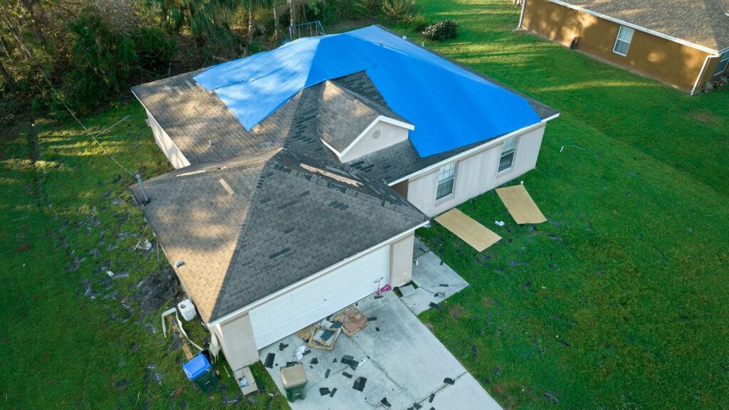 Residential roof with blue tarp during repair